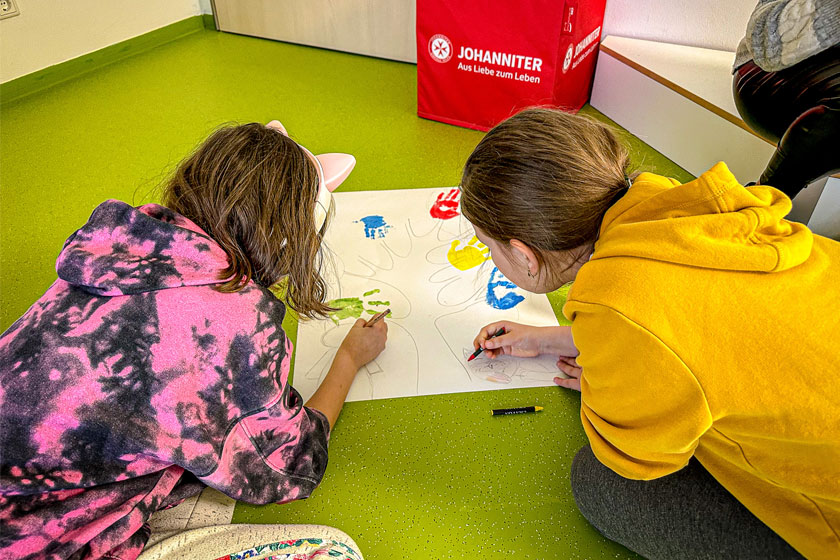 2 Kinder malen zusammen ein Bild.