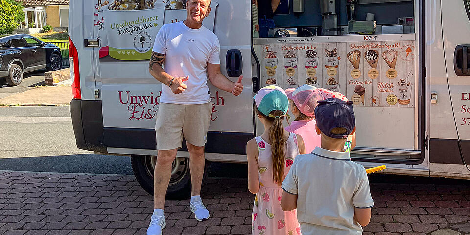 Ein Mann und Kinder vor einem Eiswagen