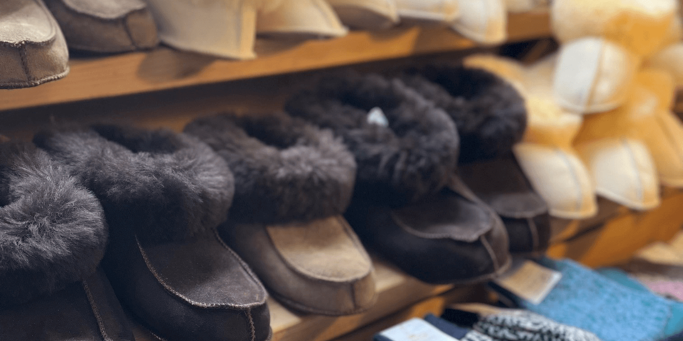 Wollsocken und fellgefütterte Hausschuhe in einem Regal