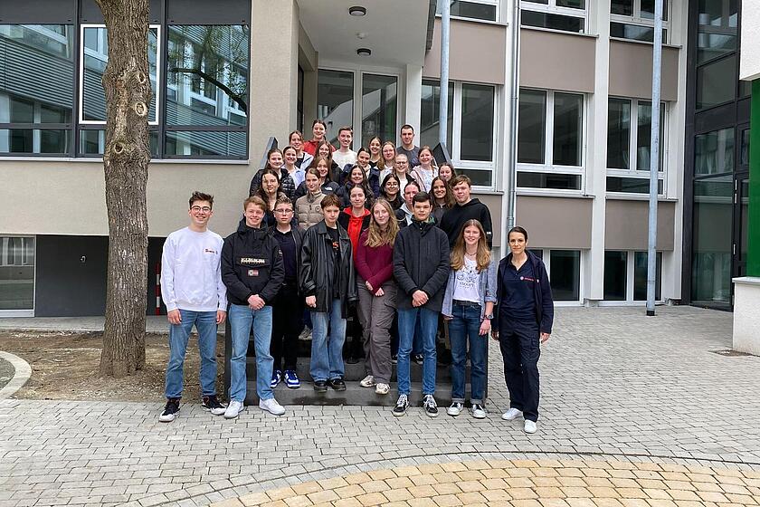 Eine Gruppe von Schülern steht vor der Schule. 
