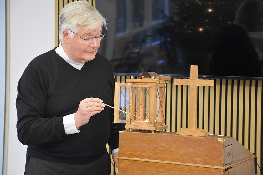 Ein Pastor entzündet eine Kerze