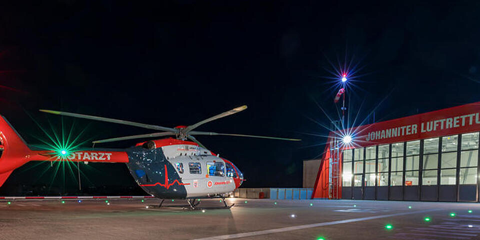 Helikopter steht in der Nacht auf dem Landeplatz vor der Zentrale der Johanniter Luftrettung