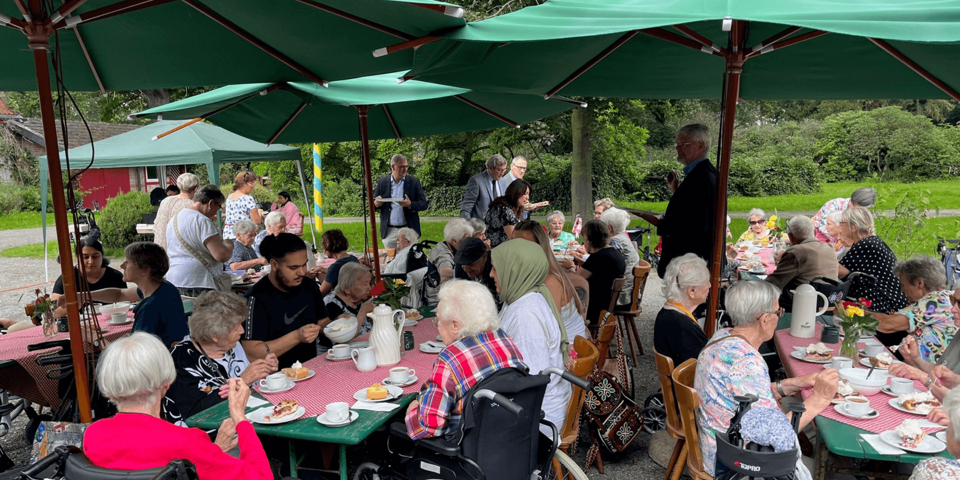 mehrere Kaffeetische unter großen grünen Schirmen