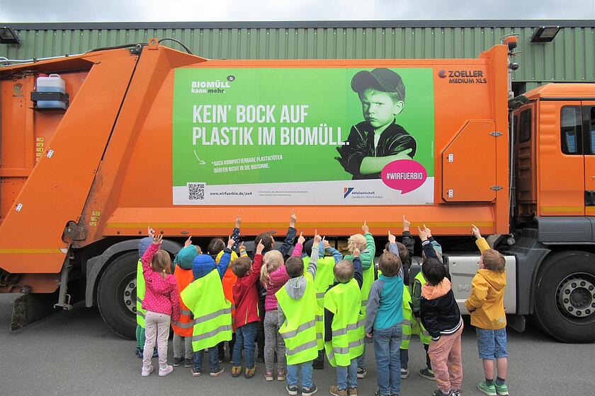 Kinder vor einem Müllwagen