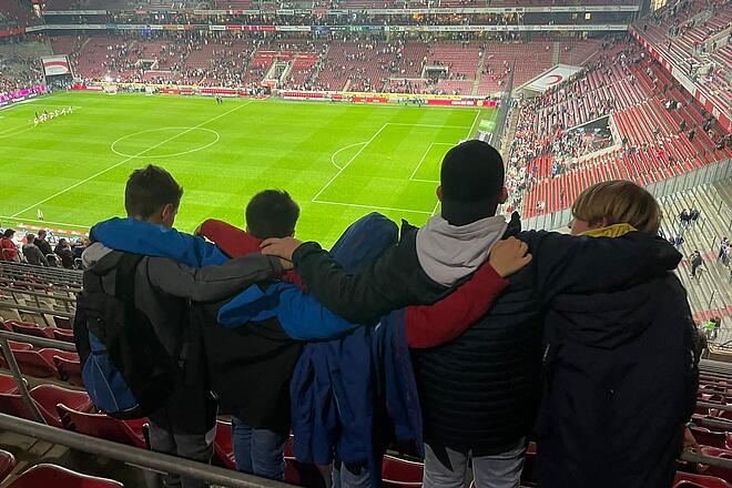 Kinder besuchen schauen auf das Spielfeld im Stadion
