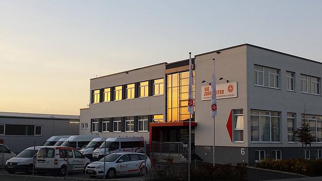 Johanniter Geschäftsstelle Griesheim in der Abenddämmerung mit Sicht auf die Fahrzeuge und die linke Gebäudeseite