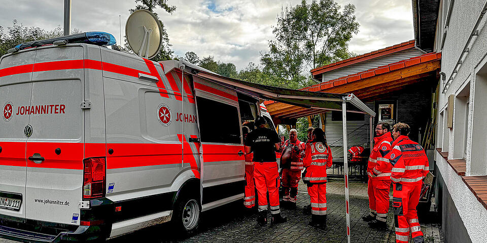Einsatzkräfte vor einem Einsatzleitwagen