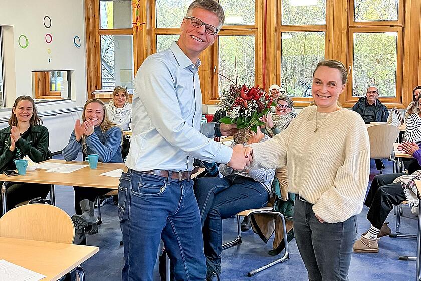 Peter Küpper überreicht Nora Riemichen einen Blumenstrauß.