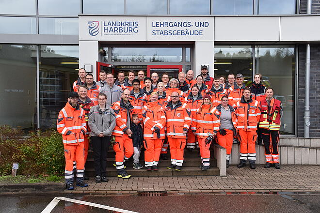 Mehr als 30 ehrenamtlich Helfende stehen vor der Feuerwehrtechnischen Zentrale in Hittfeld
