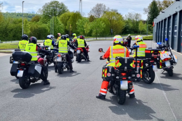 Mehrere Motorräder bzw. Motorradfahrende stehen startbereit vor der Regionalgeschäftsstelle der Johanniter Lippe-Höxter. Einige tragen Einsatzkleidung. Sie starten zu den speziellen Erste-Hilfe-Kurs für Motorradfahrende.