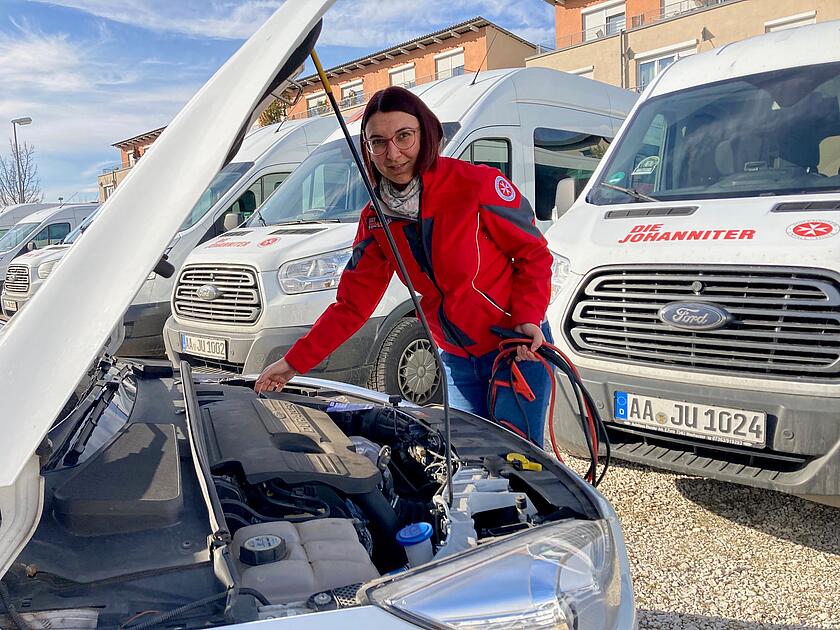 Johanniterin an offener Motorhaube