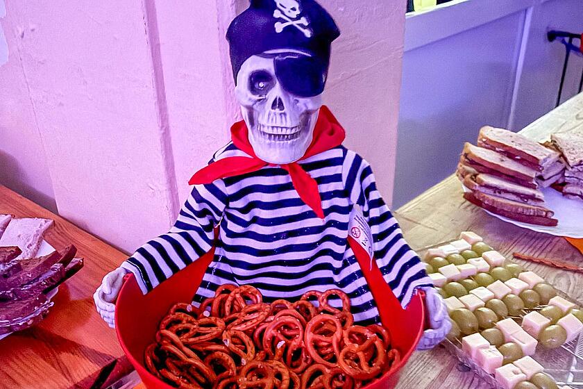Das Buffet bei der Halloween-Party in der Johanniter-Kita Traumland wurde von den Eltern der Kinder organisiert. Ein Figur (Skelett-Pirat) hält eine Schüssel mit Mini-Brezeln.