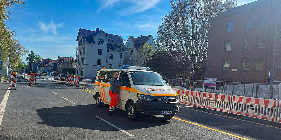Ein Johanniter-Fahrzeug und ein Johanniter auf einer abgesperrten Straße