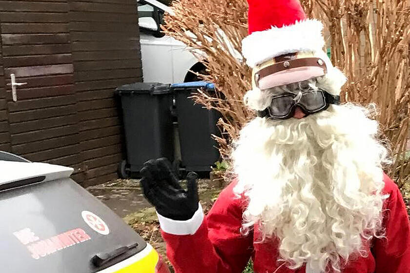 Ein als Nikolaus verkleideter Mann winkt in die Kamera. 