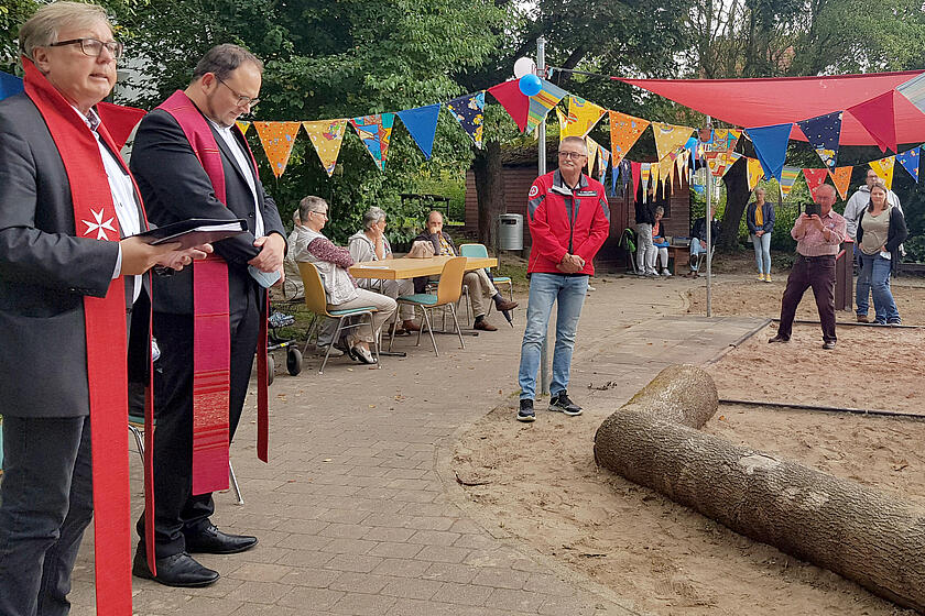 Zwei Pastoren segnen in Anwesenheit von Gästen den Spielplatz