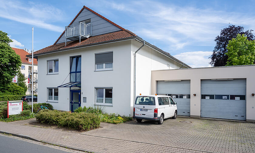 Ein weißes zweistöckiges Haus mit zwei Garagen.