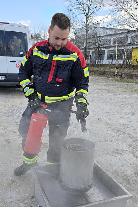 Ein Ausbilder der pflegewohnen.livemonstriert den Umgang mit einem Feuerlöscher