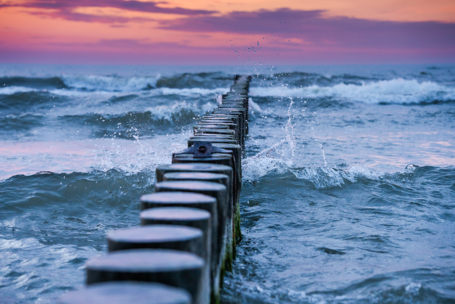 Buhnen im Meer vor einem Sonnenuntergang