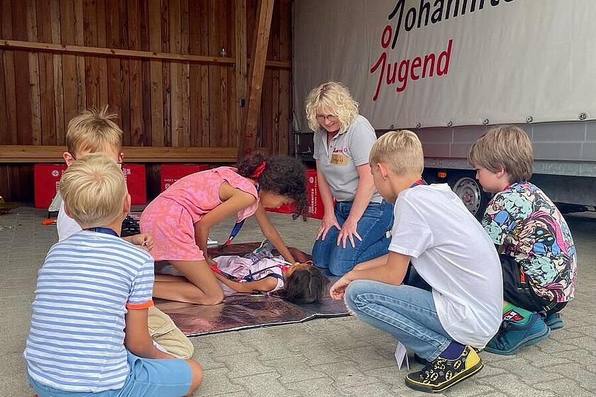 Mehrere Kinder üben Reanimationsmaßnahmen