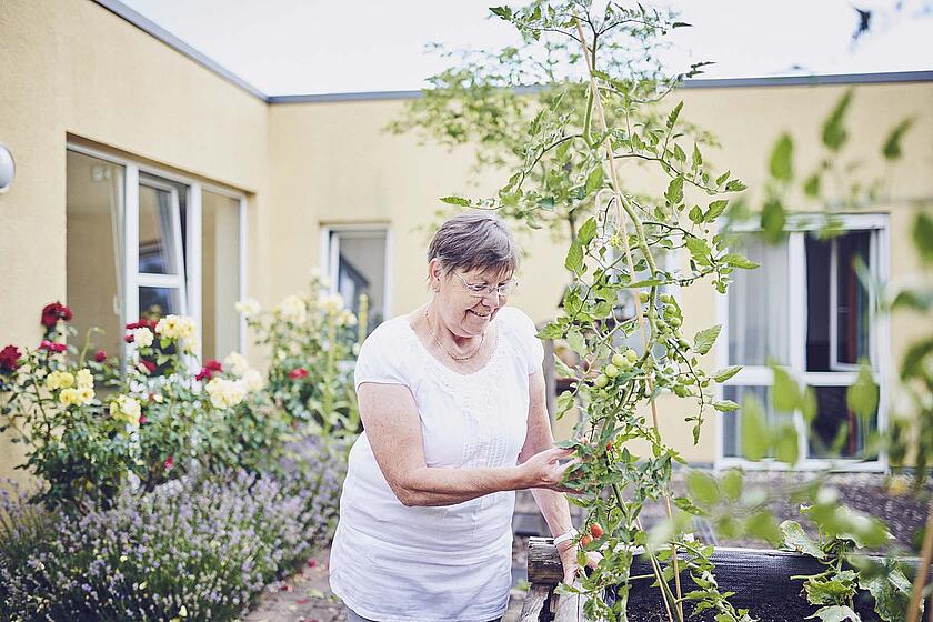 Eine Bewohnerin bei der Gartenarbeit