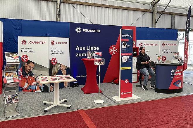 Am Johanniter-Infostand auf dem Maimarkt 2026 stellen die Johanniter u.a. die Hausnotrufgeräte aus, bieten diverse Infoblätter und einen Memory-Spiel für Kinder an.