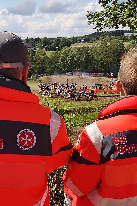 Zwei Johanniter beim Sanitätsdienst während eines Motocross-Rennens