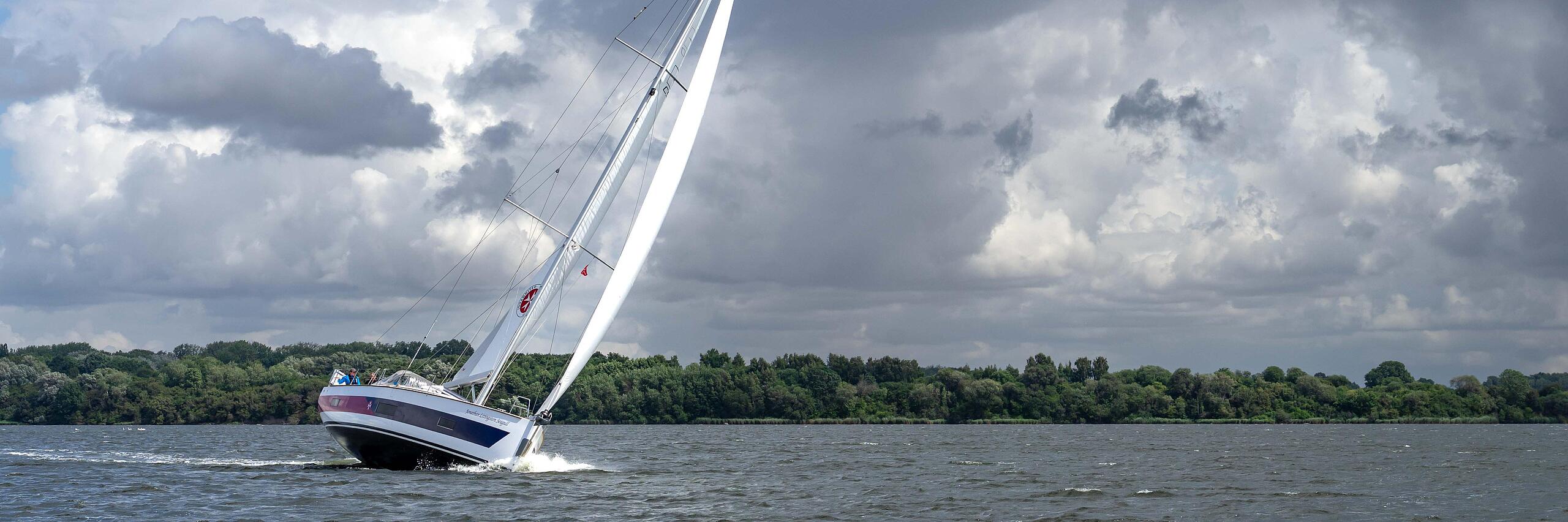 Segelboot der Johanniter mit gesetzten Segeln auf der Pötenitzer Wiek bei Travemünde.