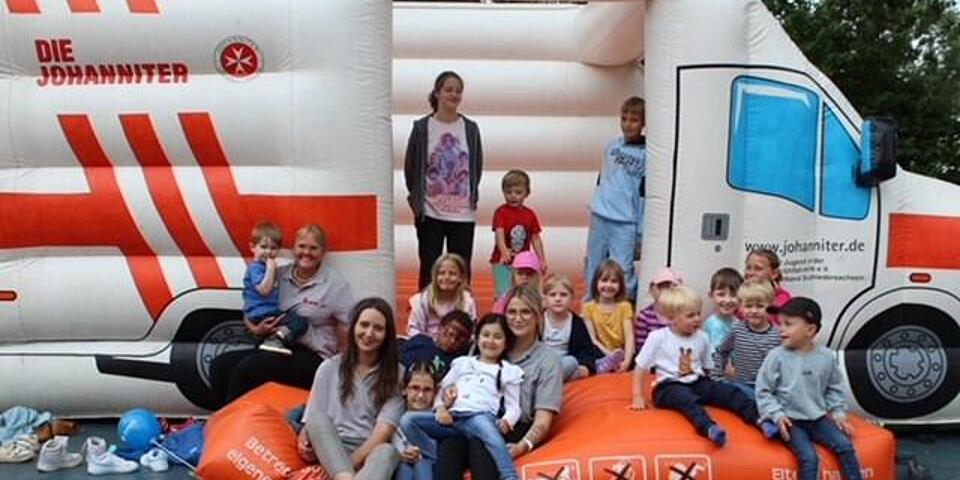 Kinder auf einer Hüpfburg mit Erzieherinnen